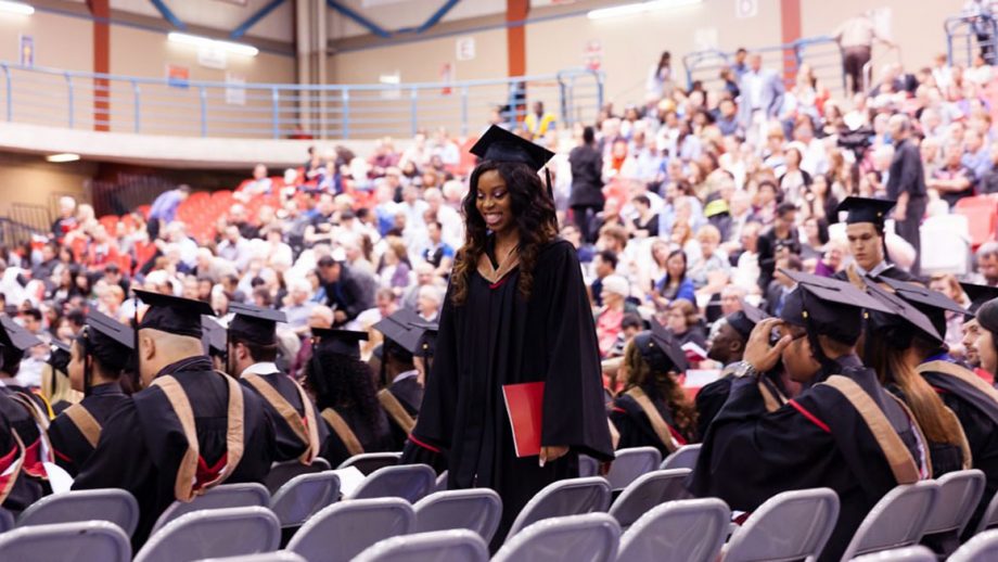 Student walking to seat smiling