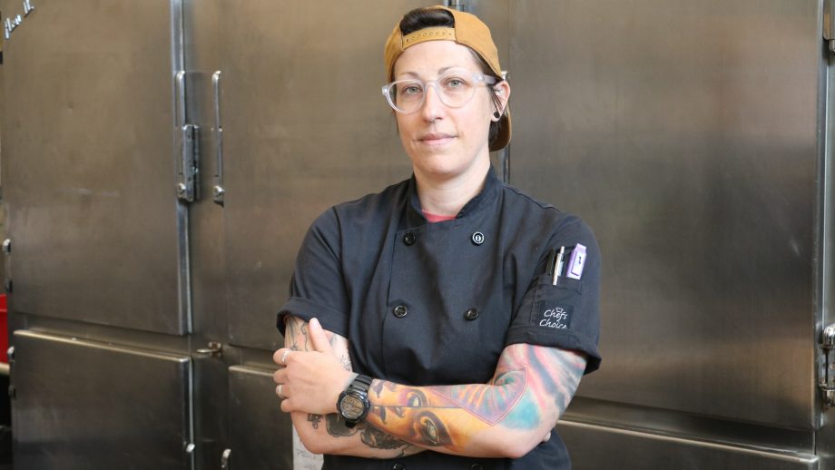 Chef Jessica Young standing in front of stainless steal coolers.