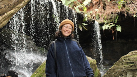 Photo of Dominique Carrière in front of a waterfall.
