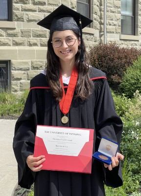 Maddy Nowosad holds her degree and the Mayor's Medal.