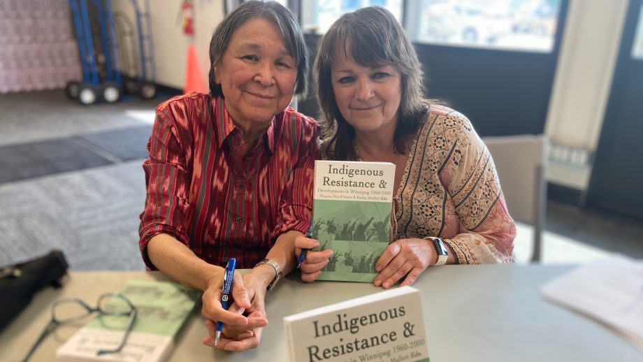 Kathy Mallett and Dr. Shauna MacKinnon holding the book 'Indigenous Resistance & Development in Winnipeg, 1960-2000' during its launch.