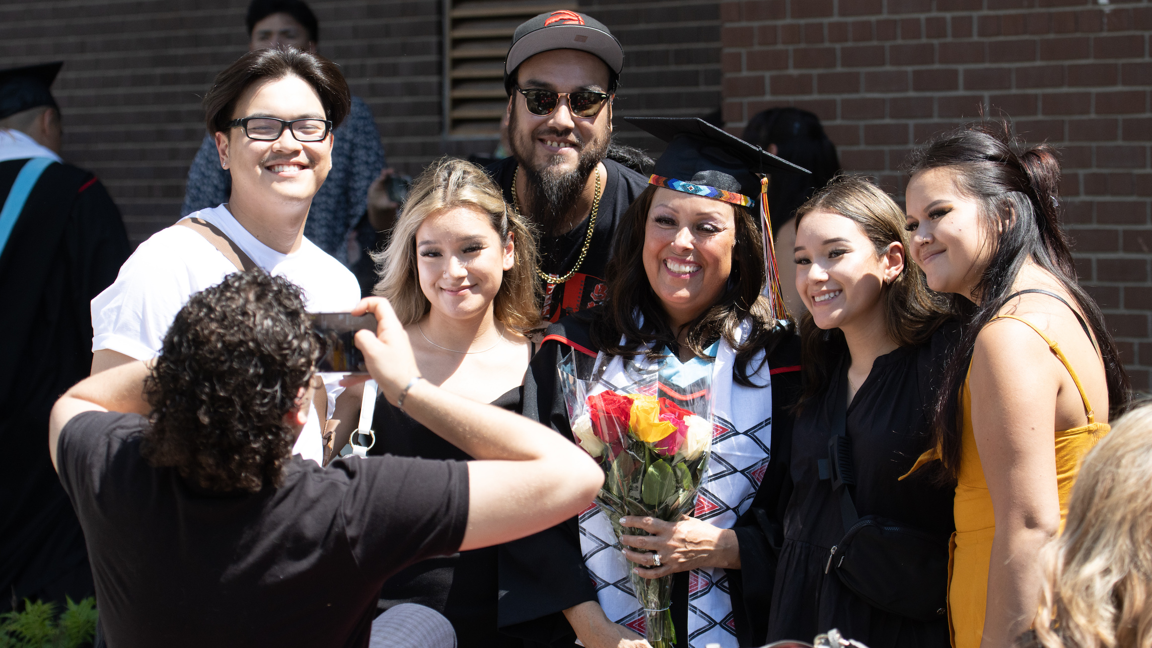 A graduate poses for a photo with friends and family after Convocation.