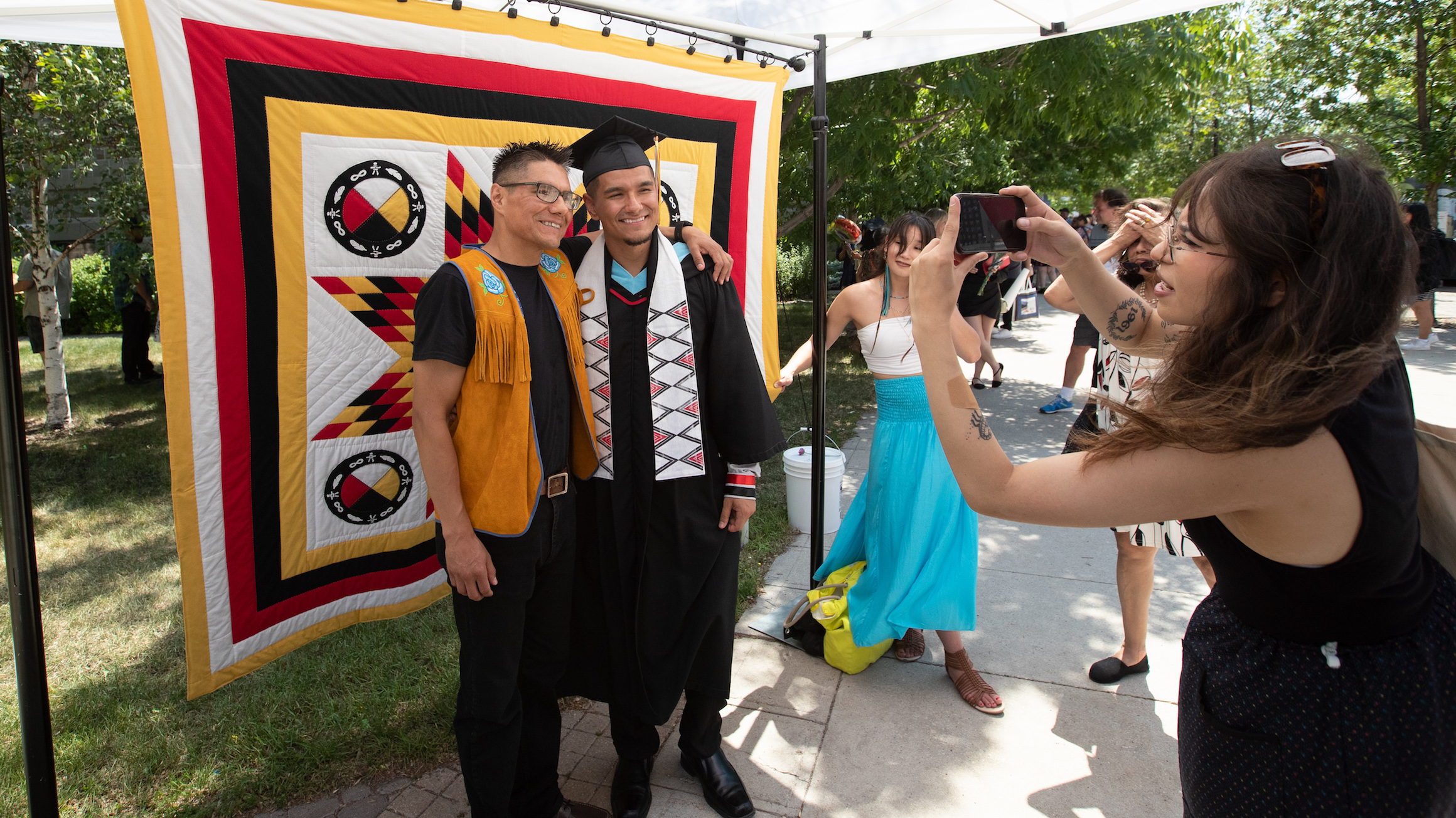 An Indigenous graduate poses for a photo after Convocation.