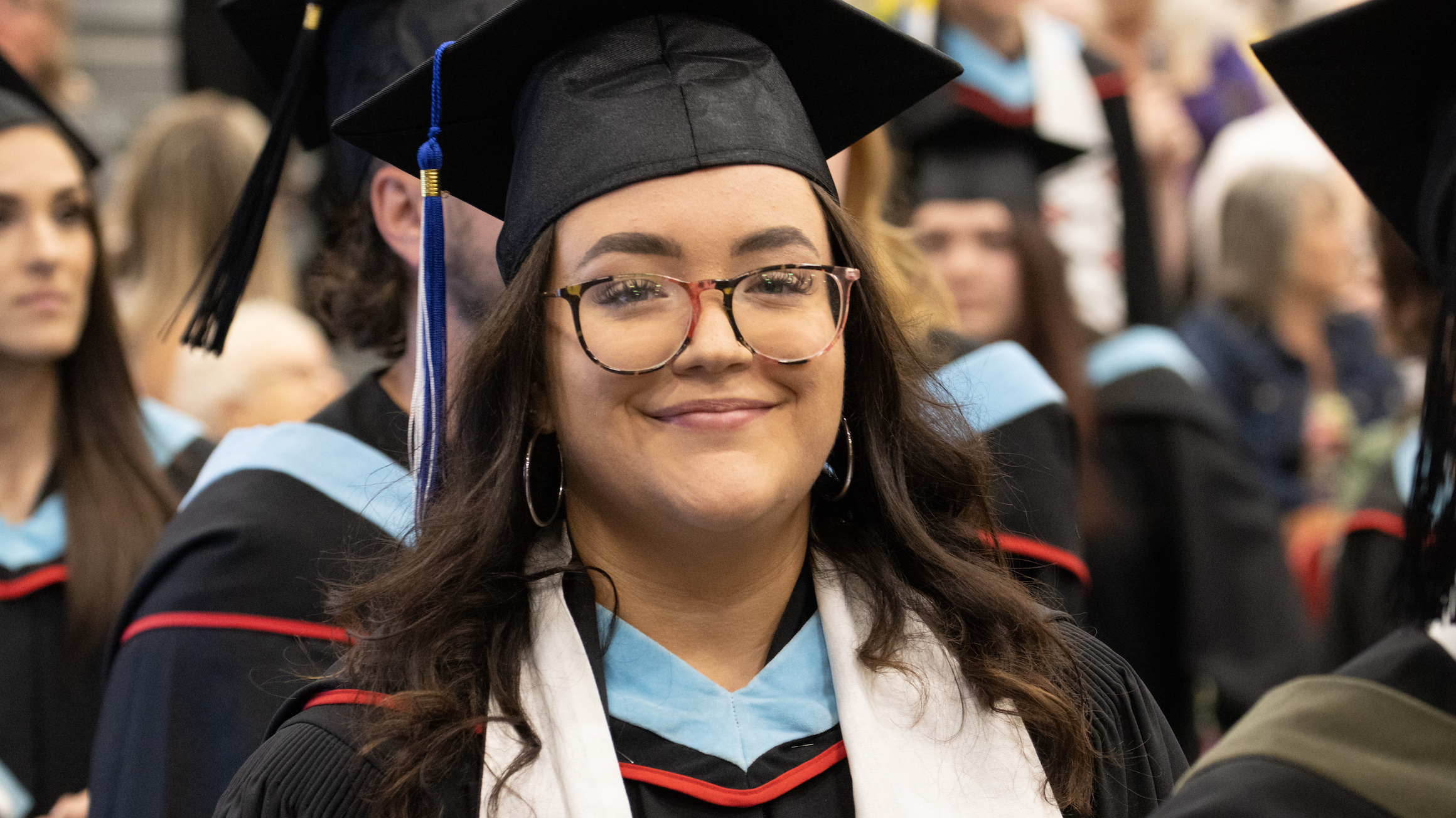 A smiling student entering Convocation at the Duckworth Centre.