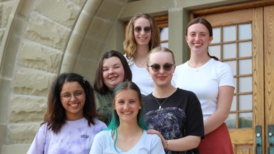 Six Peer Wellness Educators gather for a group portrait on the front steps of Wesley Hall.