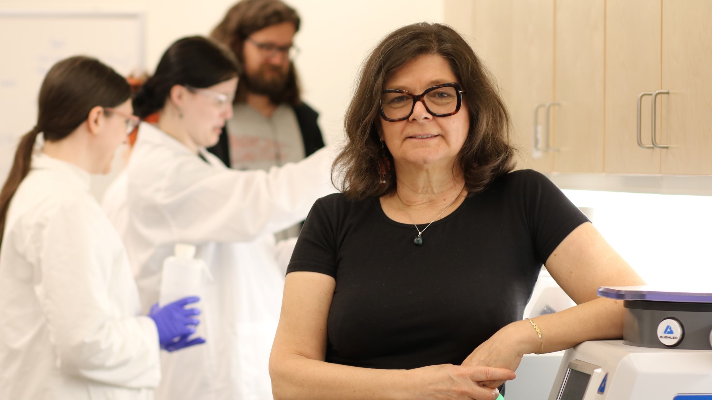 Dr. Mirjanda Roksandic in a lab with students working in the background.