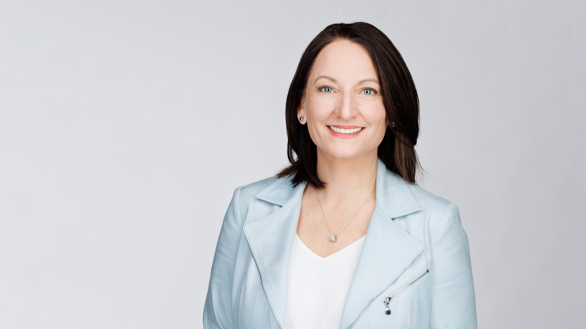 Danielle Dunbar standing in front of a grey background.