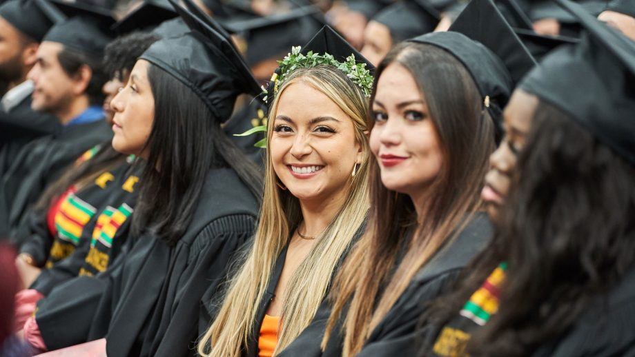 Graduating PACE students seated in caps and gowns.