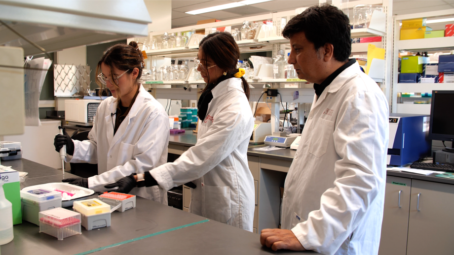 Dr. Shrivastav and two students working in a lab.