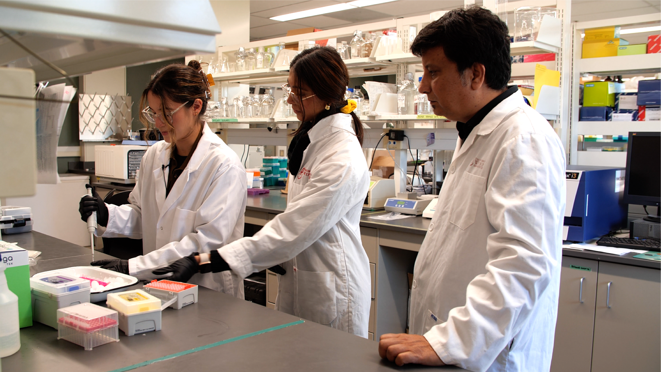 Dr. Shrivastav and two students working in a lab.