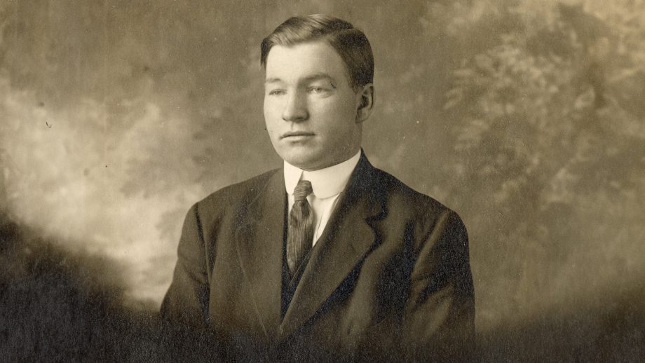 Charles Lovatt in front of a patterned background, black and white.