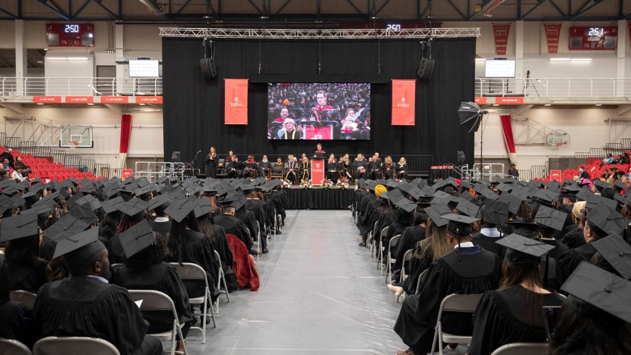 Graduates seated in front of the stage.