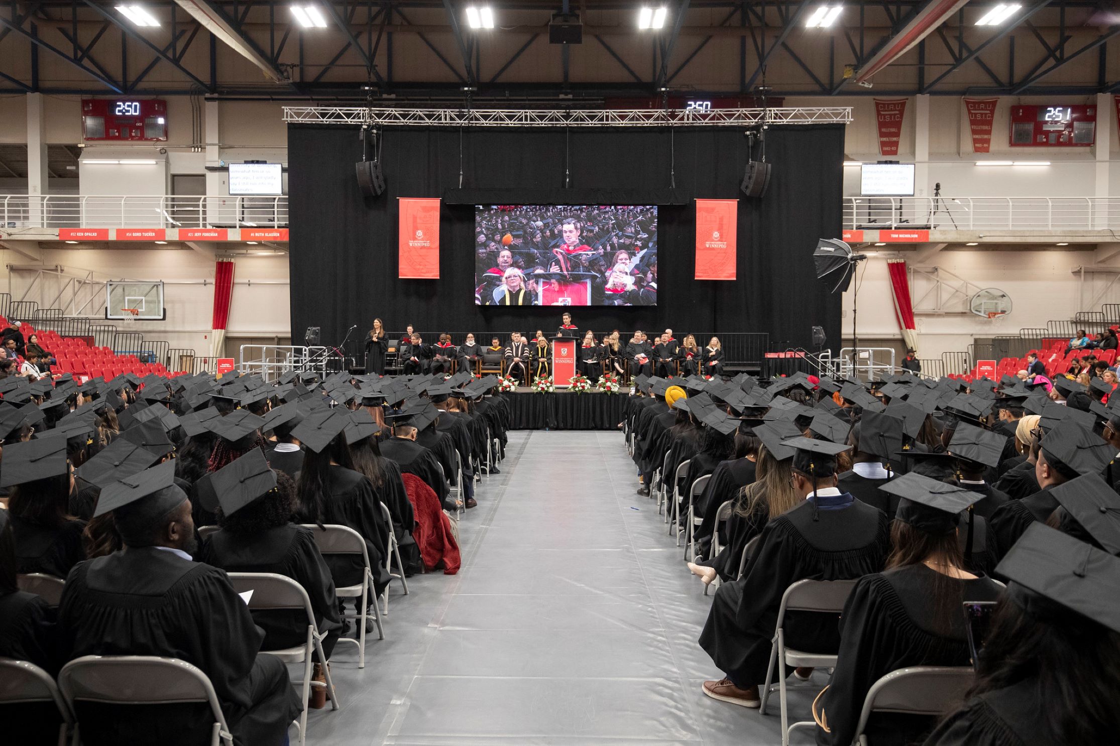 Graduates seated in front of the stage.