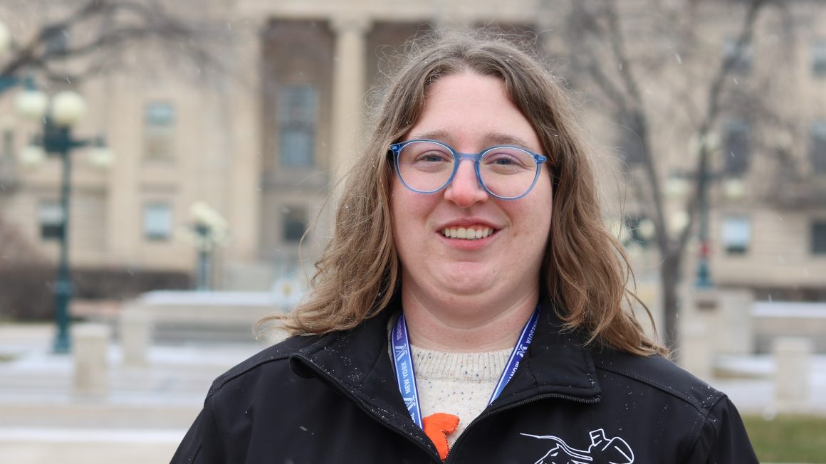 Madison Zienkiewicz standing in front of MB Legislature