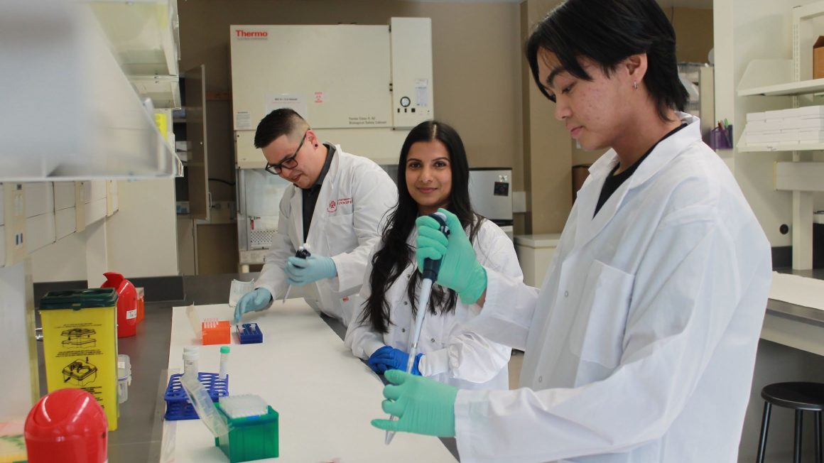 Sanoji Wijenayake in her lab with two students.