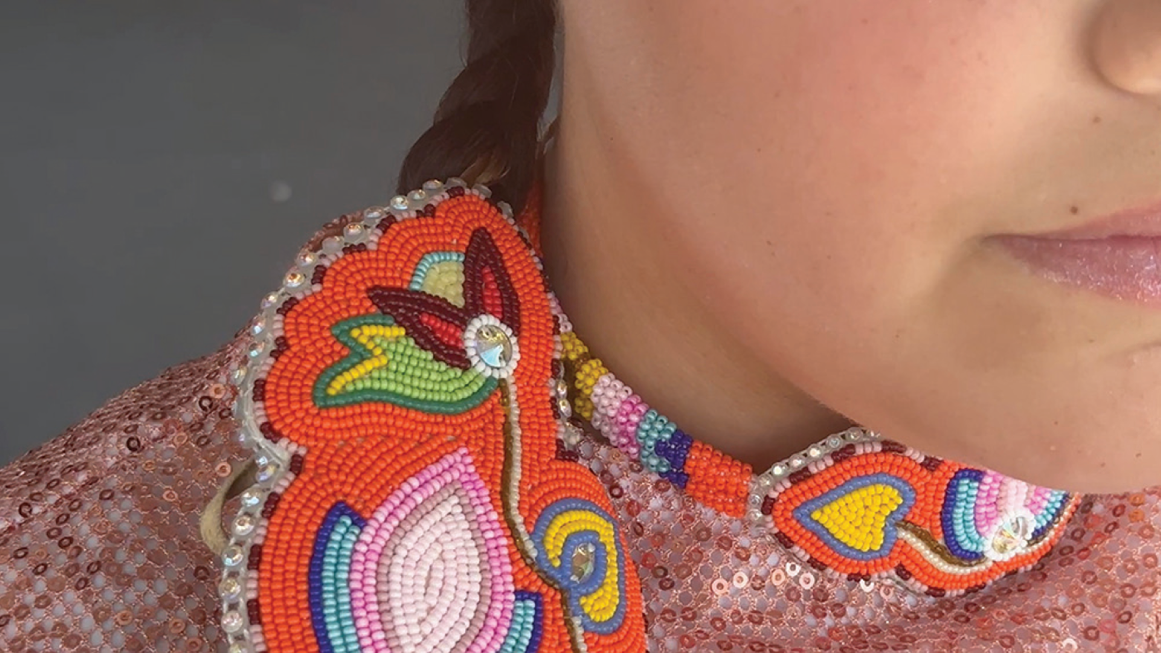 Close-up of beadwork on the collar of a person.