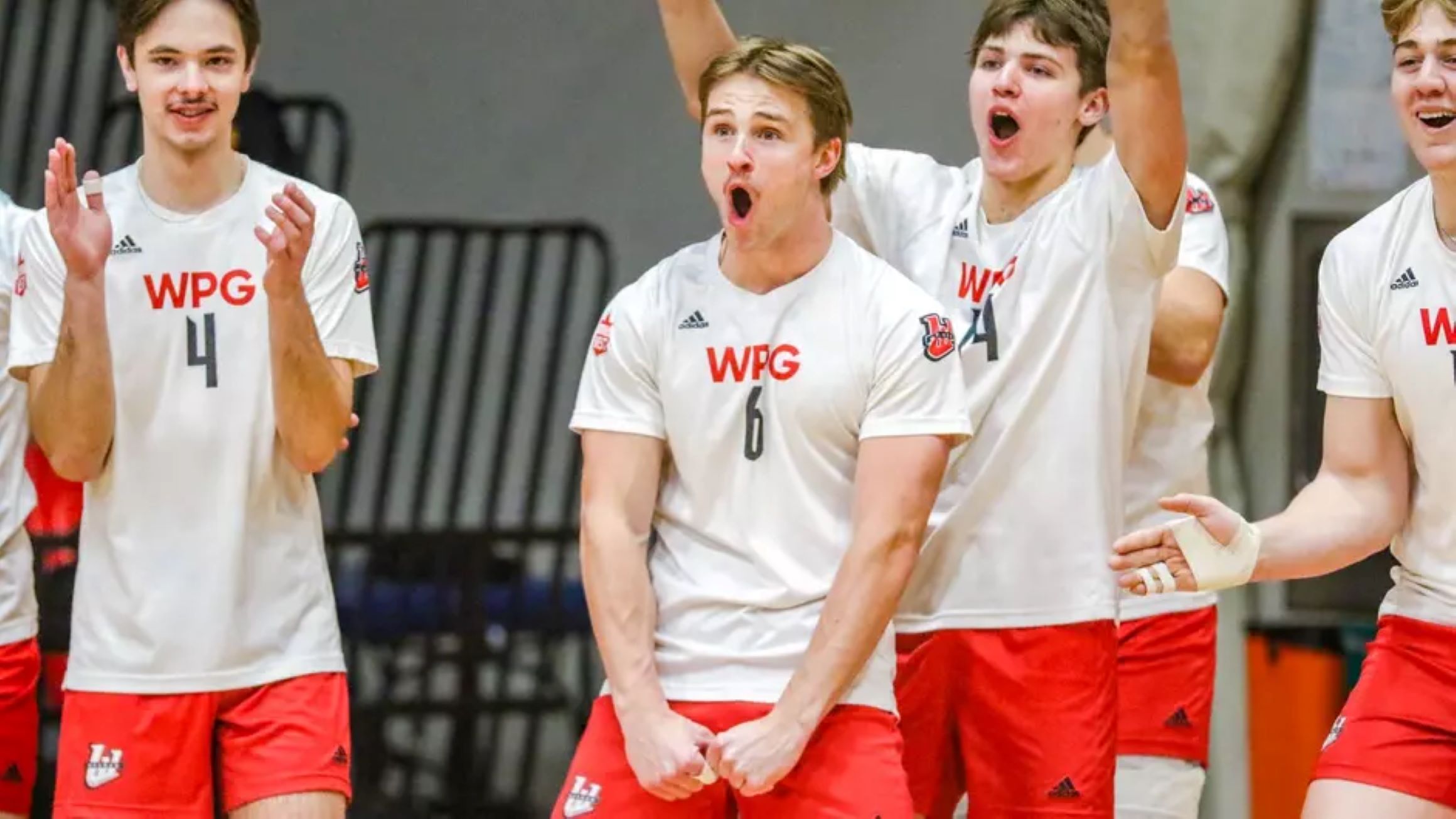 Wesmen men's volleyball team members celebrate on the court.