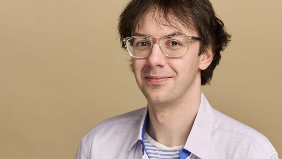 Dr. Brandon Goulding standing in front of a beige background.