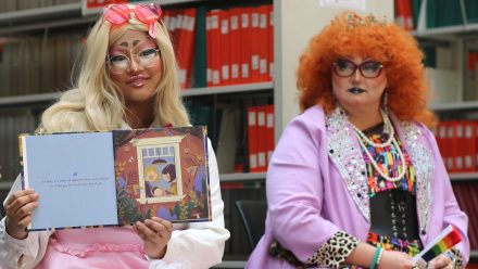 Two drag artists read a book
