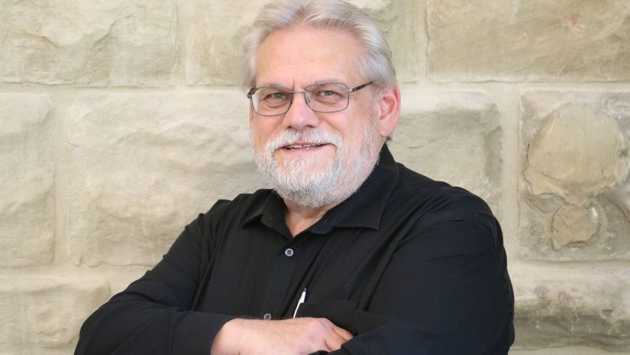 Stefan Jonasson in front of a stone wall.