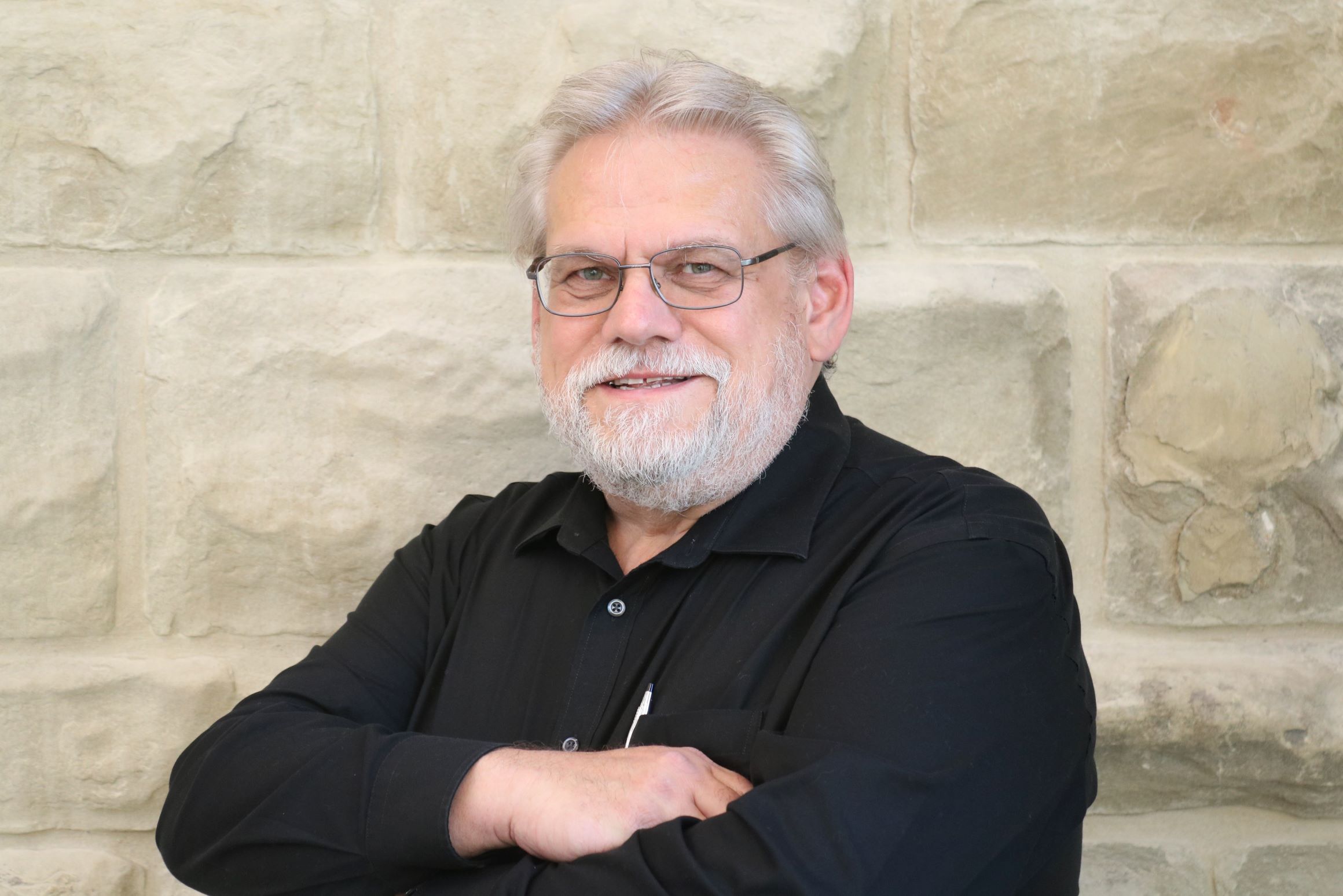 Stefan Jonasson in front of a stone wall.