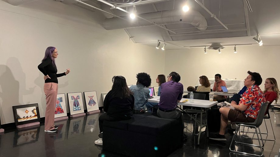 Dr. Cathy Mattes standing and teaching a group of seated students.