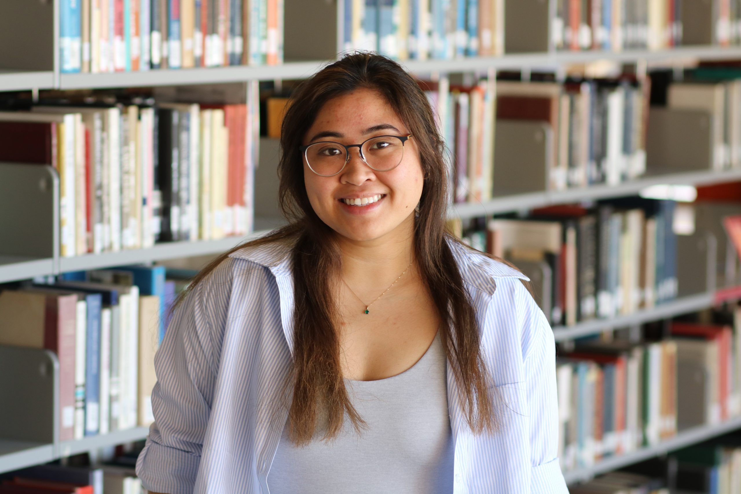 Nicole Valencia standing in the library stacks