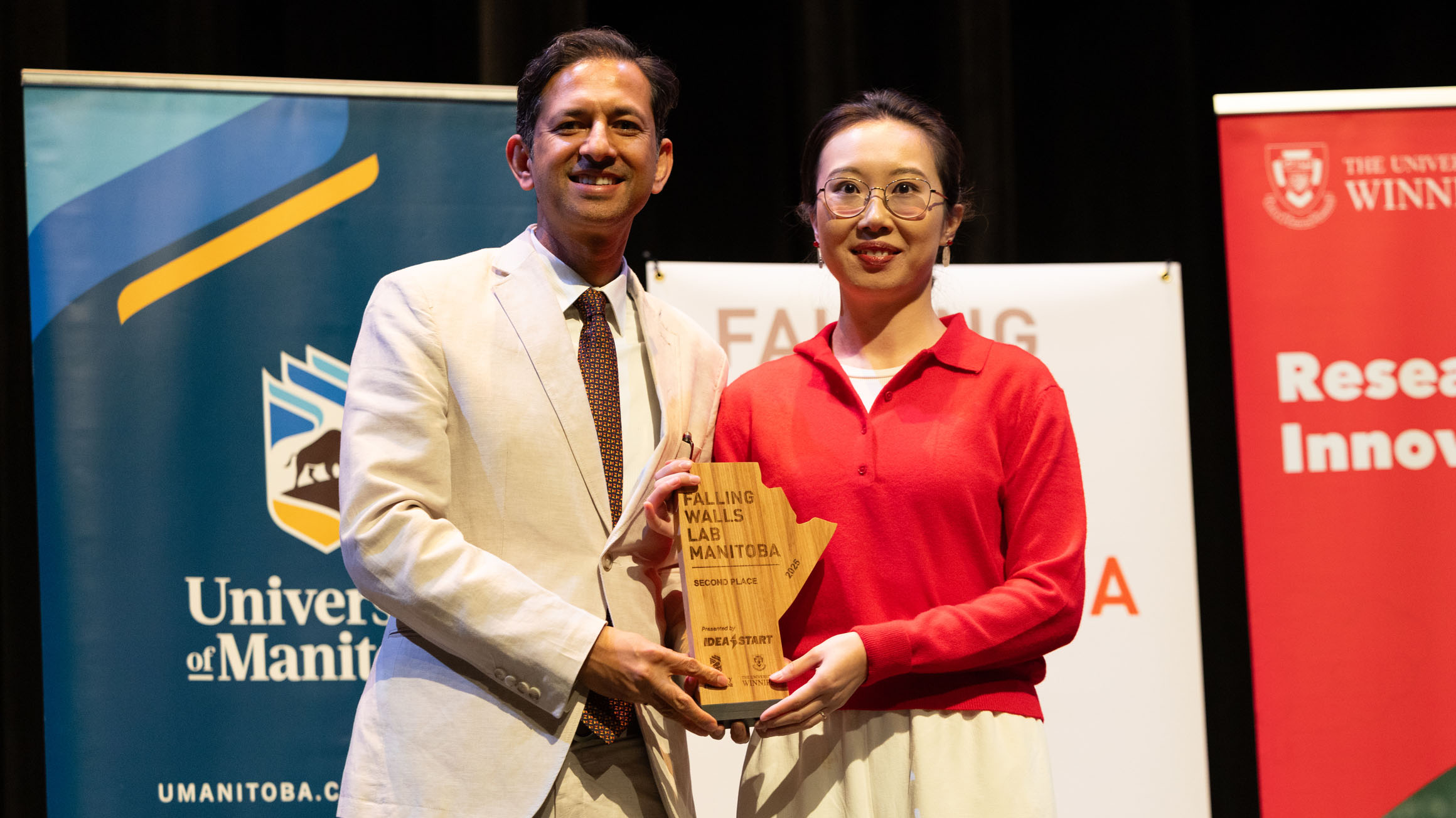 Dr. Jitendra Paliwal holding award with second prize winner Yujie Ren.