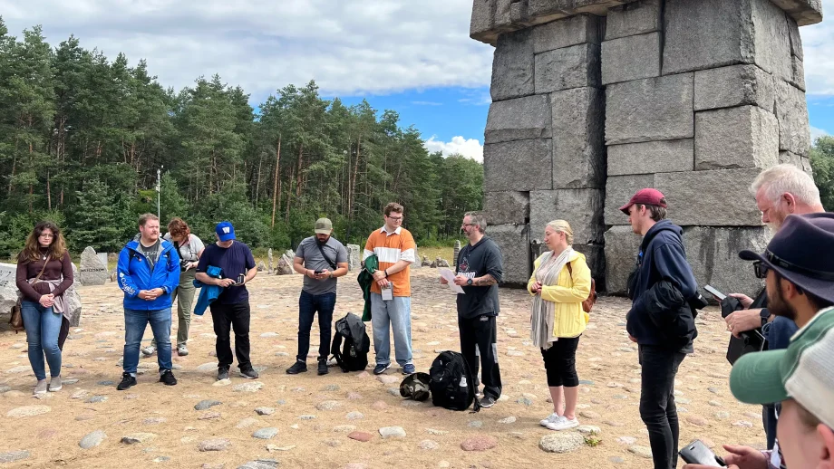 Group of people in front of a stone structure