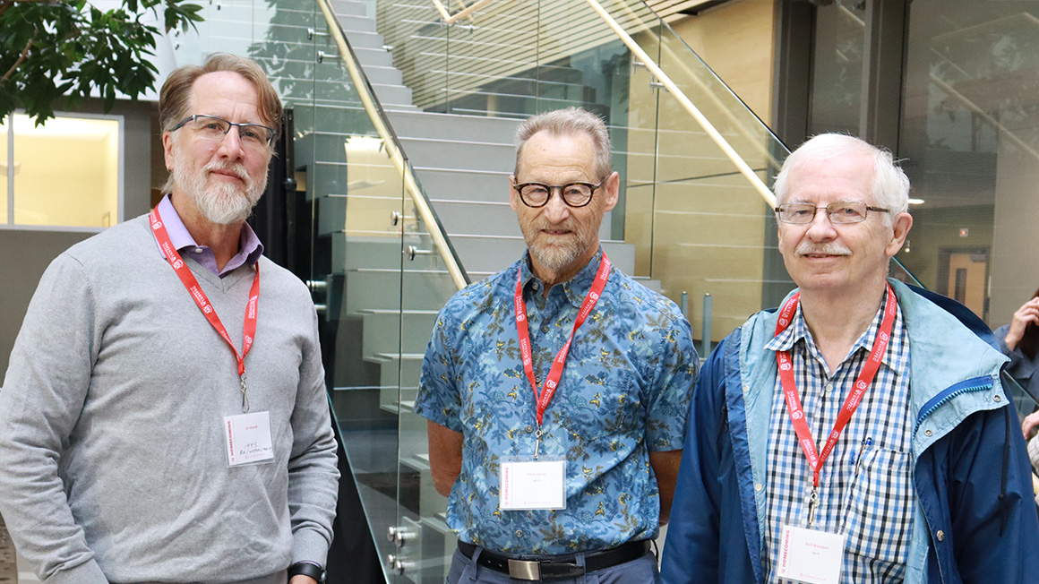Three men standing in group shot.