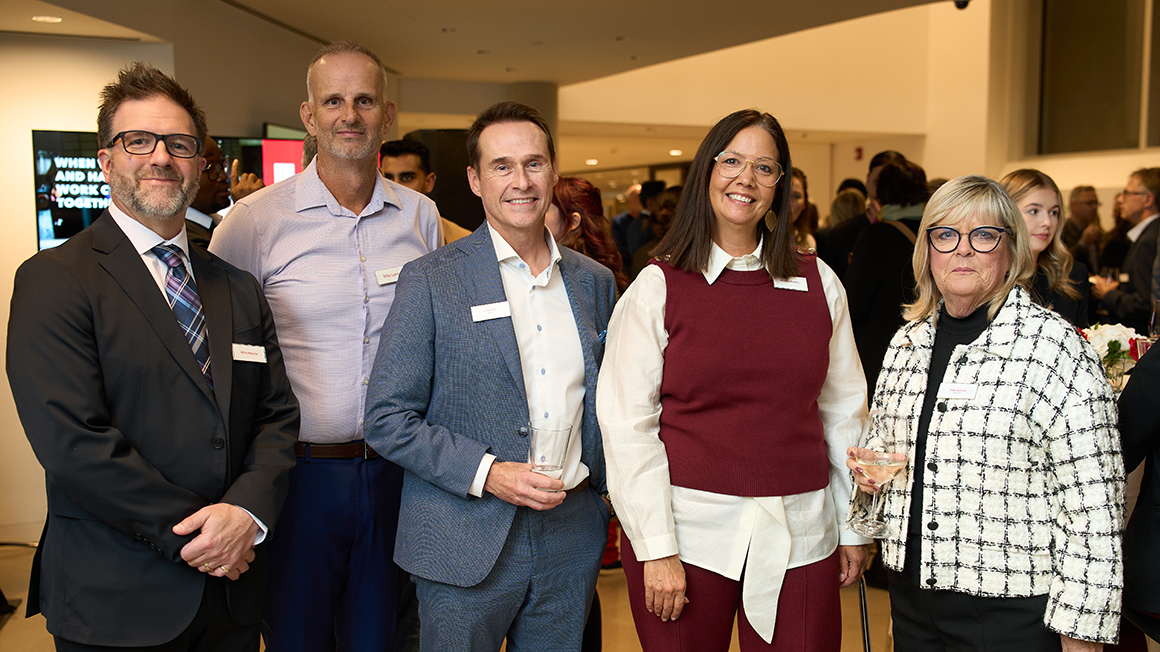 Group shot of five people standing.