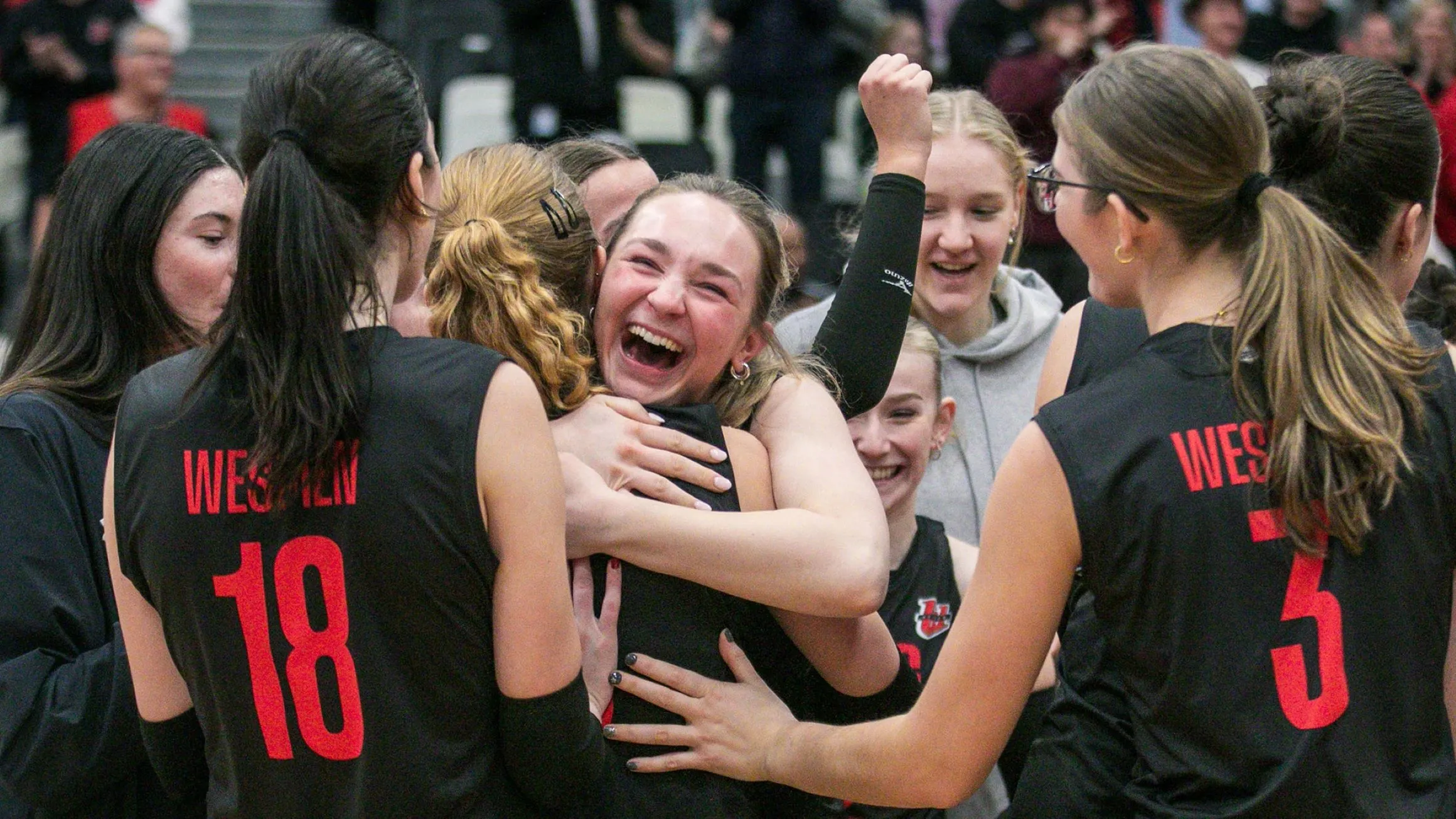 Wesmen team members celebrate on the court.