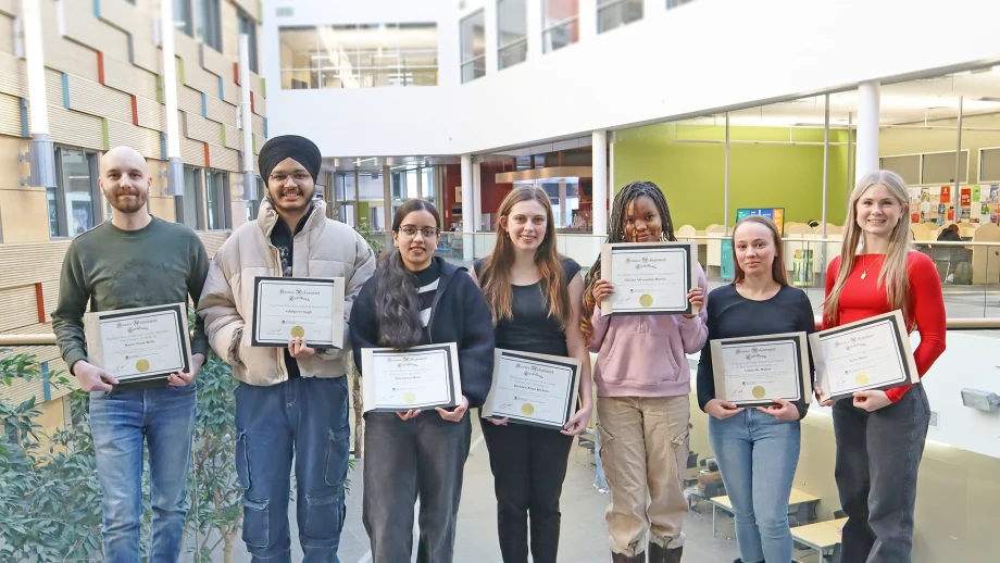 Chemistry award recipients Kurtis Boily, Sahilpreet Singh, Simarpreet Kaur, Kiersten Hiebert, Chiara Martin, Gabrielle Martin, Leiva Mann stand with their awards in an atrium.