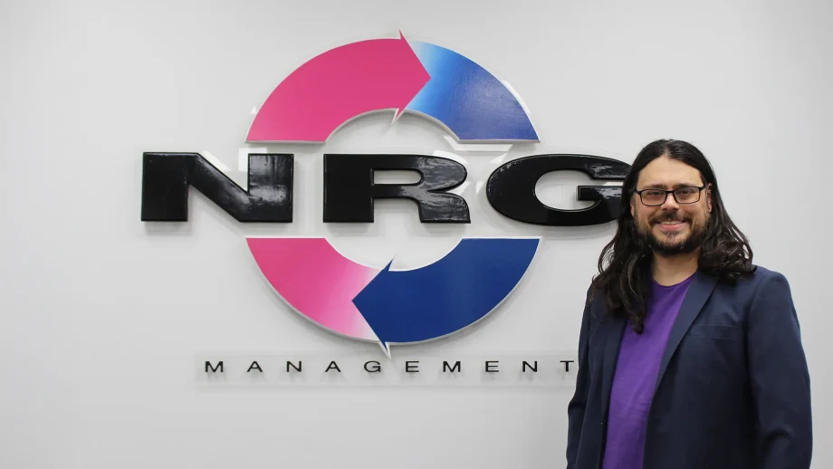 Justin Rodger standing in front of NRG Management logo