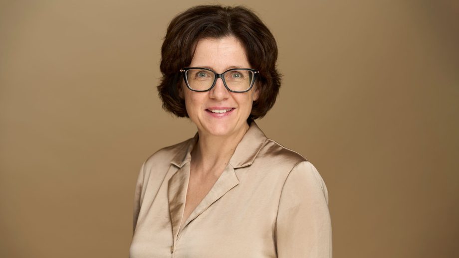 A headshot of Dr. Anna Stokke with a beige background