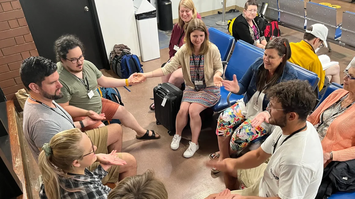 People sitting in a circle in train station.