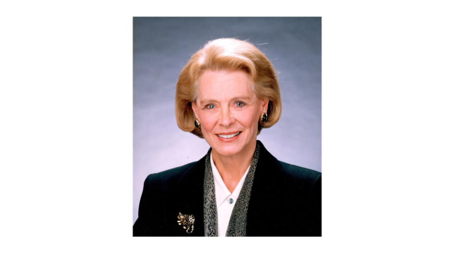 Tannis Richardson in a back jacket in front of a blue background.