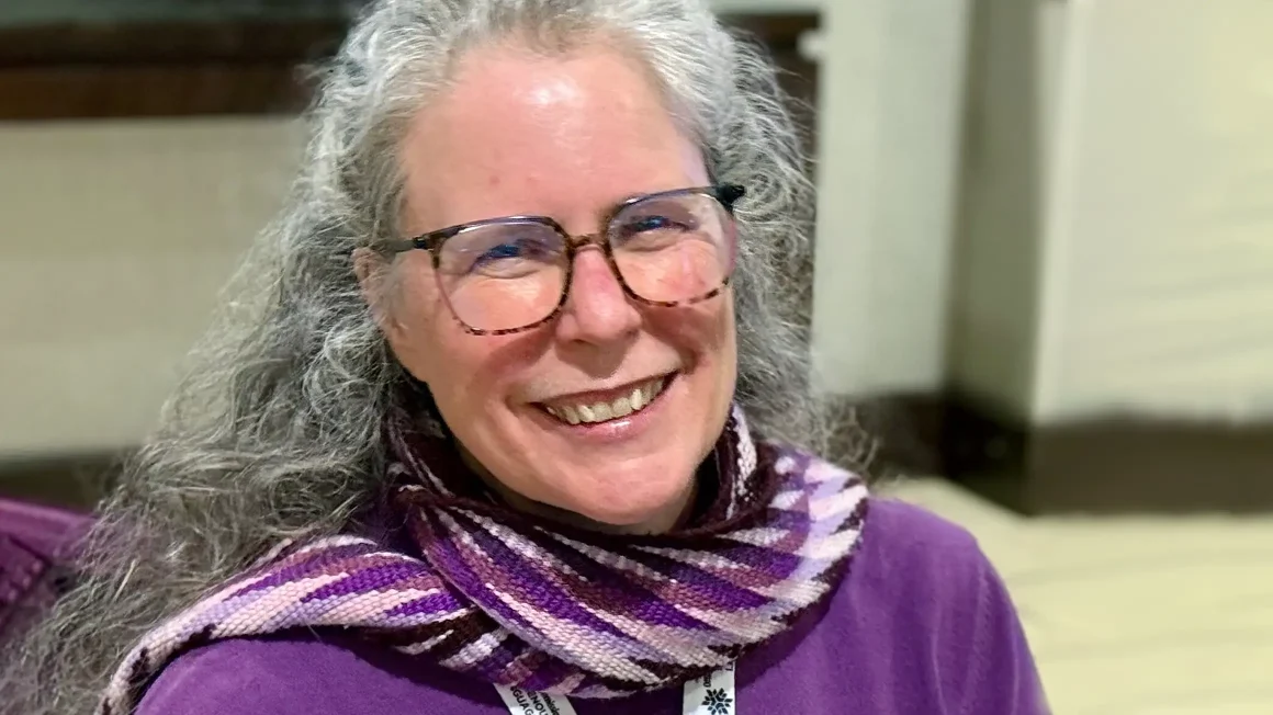 Heather Souter smiles at the camera wearing purple.