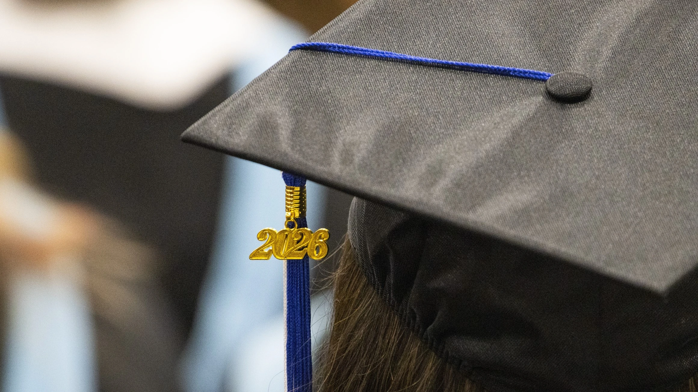 A black mortarboard graduation cap with a 2026 pendant hanging from the tassel.