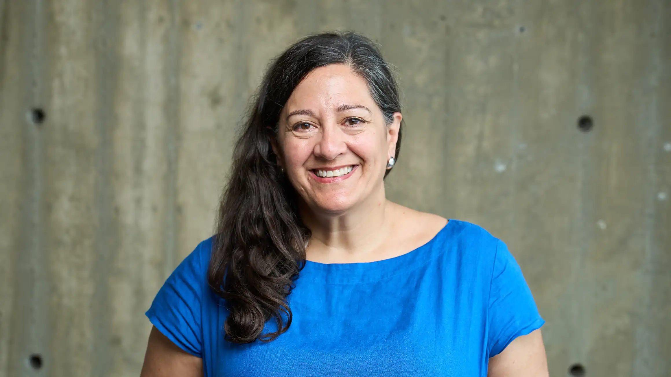 Dr. Mary Jane McCallum in a blue shirt in front of a grey background.
